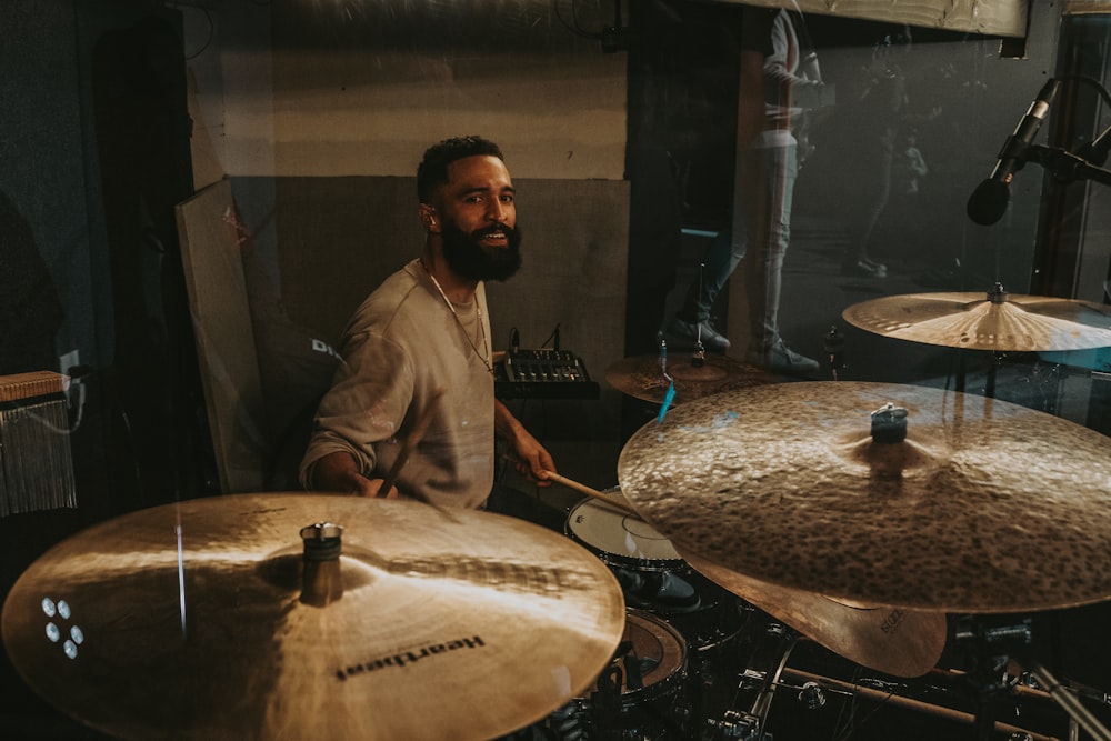 Un hombre tocando la batería en un estudio de grabación