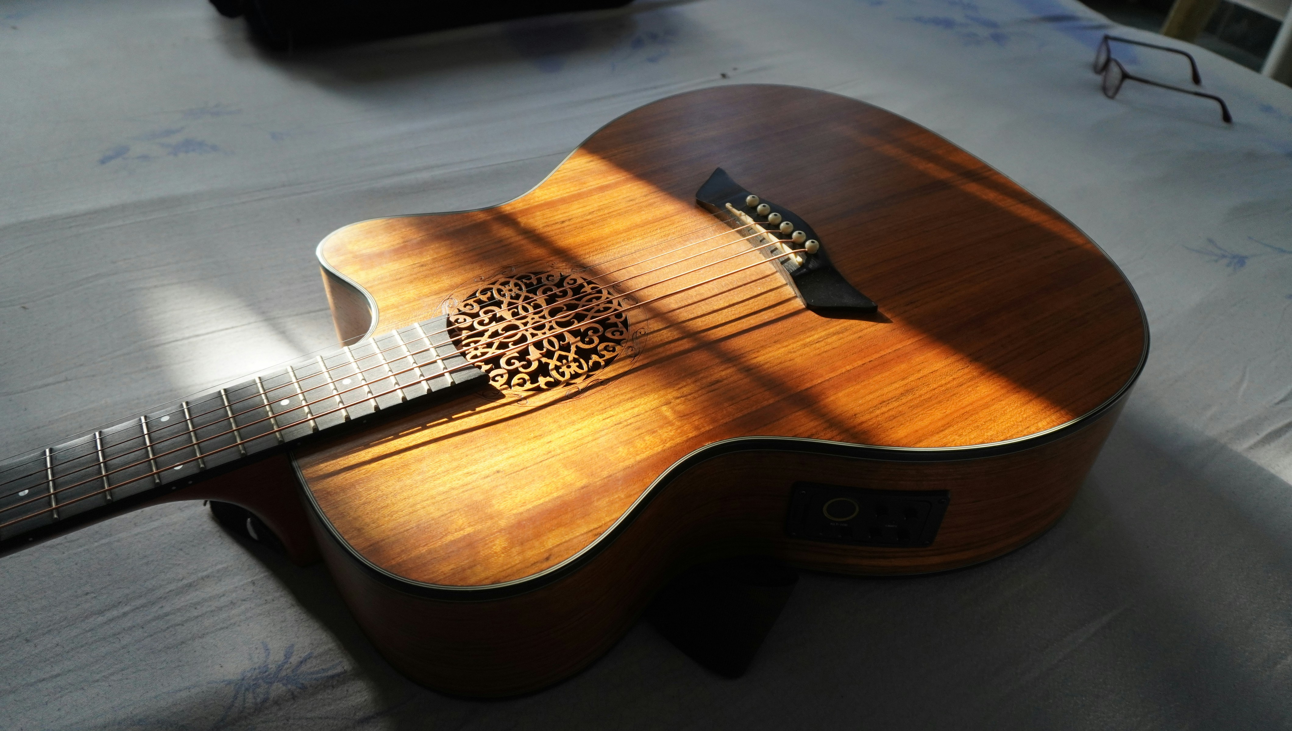 um close up de uma guitarra deitada em uma cama