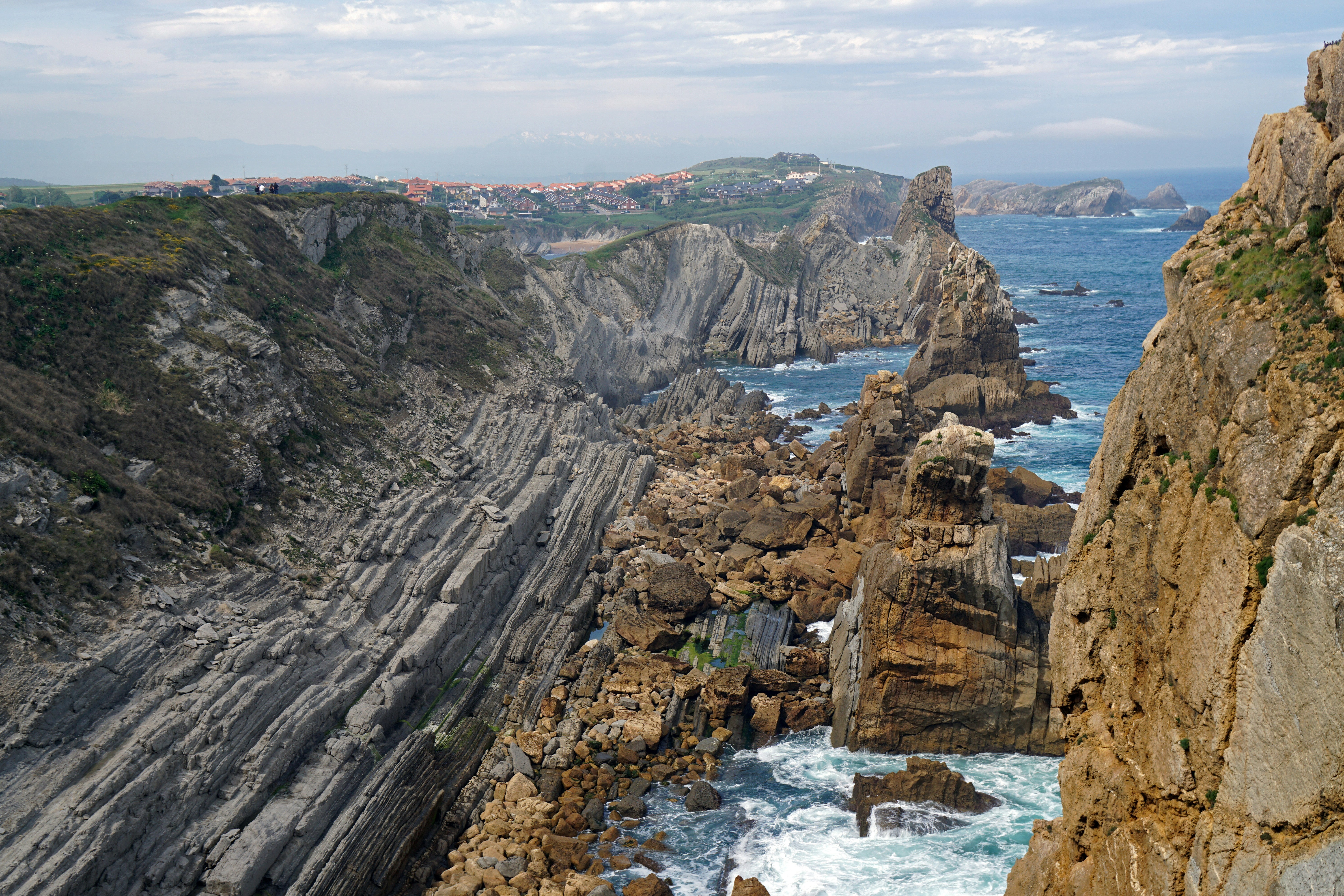 a view of a rocky coastline with waves crashing against the rocks