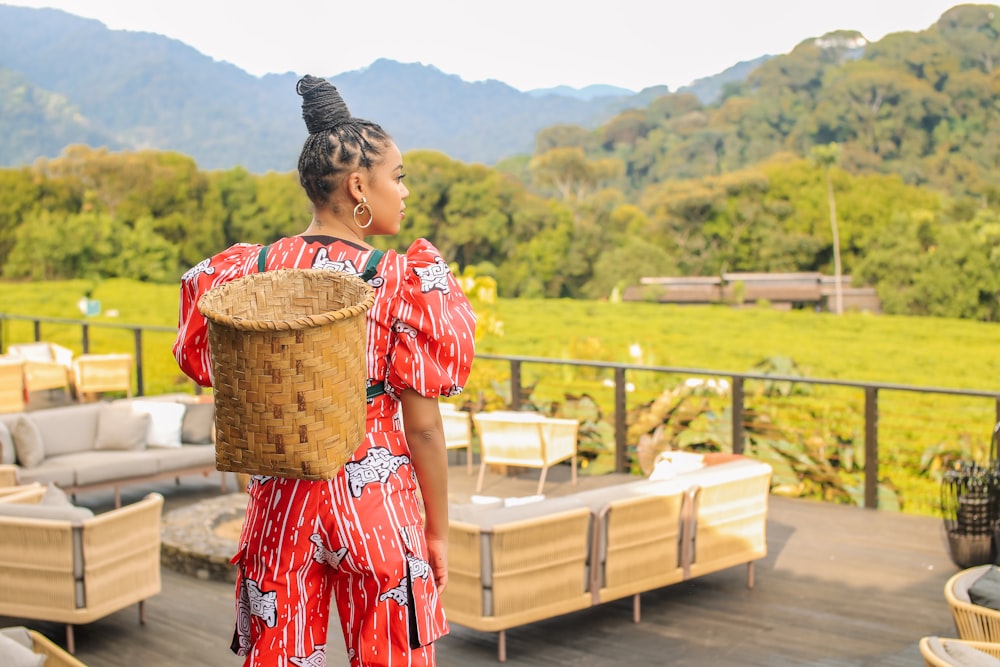 a woman in a red dress carrying a wicker basket