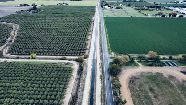 an aerial view of a road running through a field