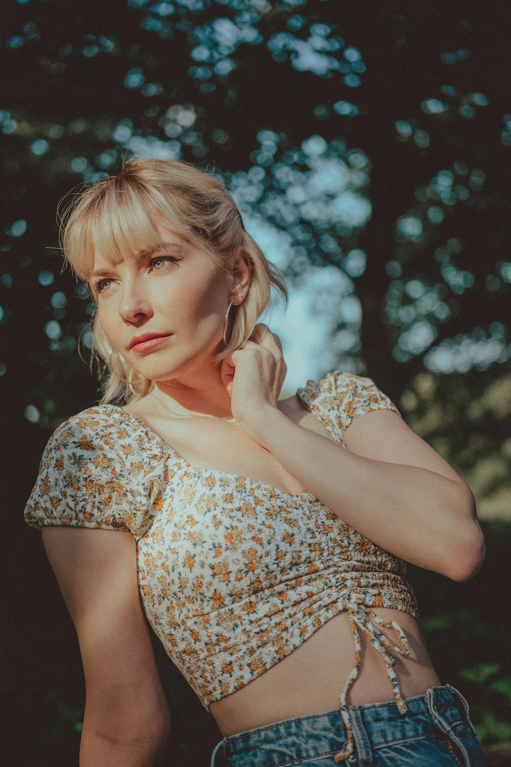 a woman in a floral top poses for a picture