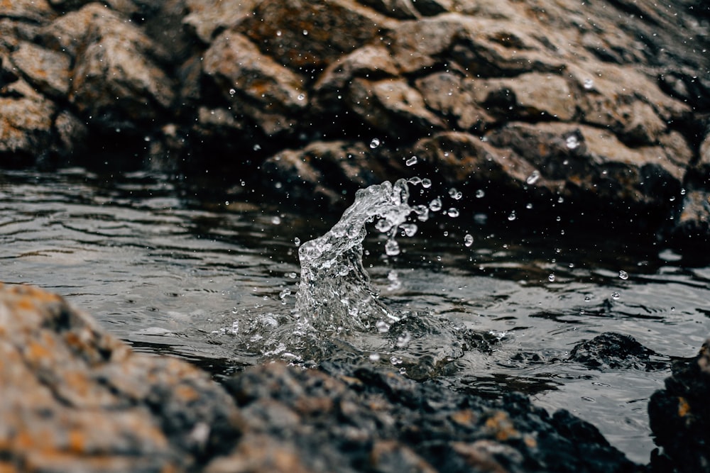 a close up of water splashing on rocks