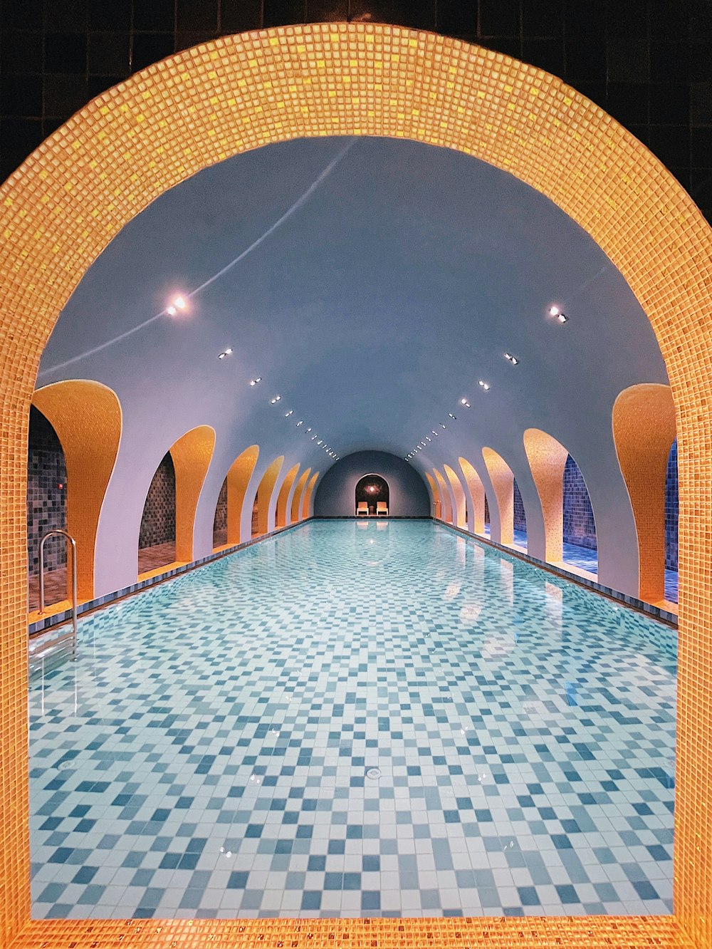 a large swimming pool surrounded by tiled walls