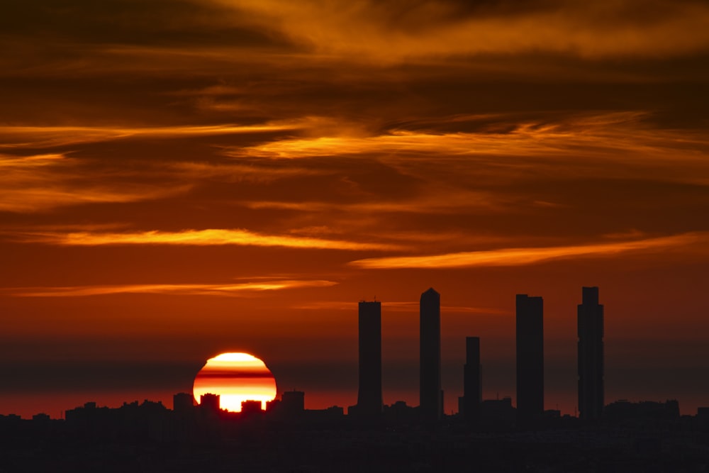 the sun is setting over a city skyline