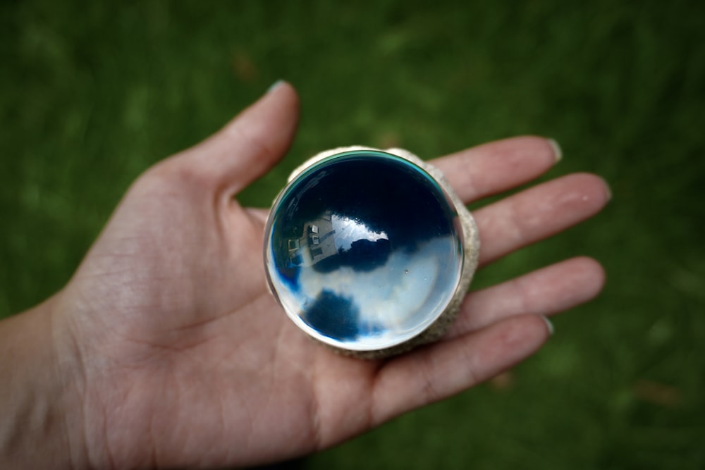 a person holding a small round object in their hand