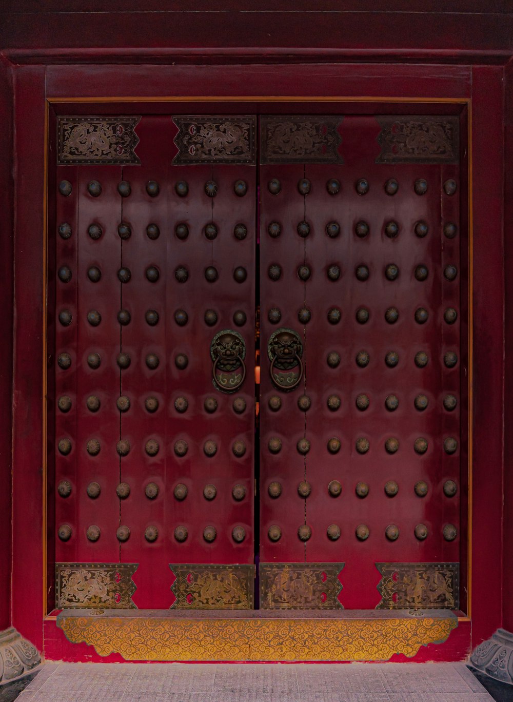 a large red door with metal knobs on it