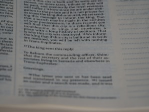 A close-up of a page from a book showing text in two columns. The text appears to be historical or biblical, indicated by the formal language and structure. The page includes a passage discussing a city's rebellious history and the response from a king.