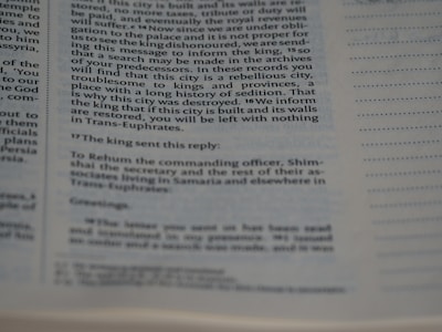 A close-up of a page from a book showing text in two columns. The text appears to be historical or biblical, indicated by the formal language and structure. The page includes a passage discussing a city's rebellious history and the response from a king.