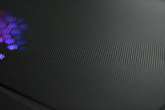 Abstract close-up of titanium silver texture with subtle purple highlights and neon glow