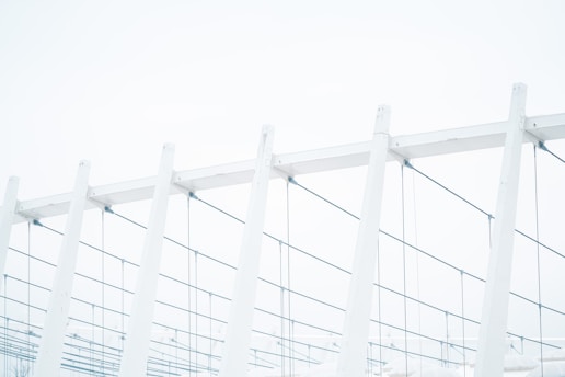 a row of white poles with a sky in the background
