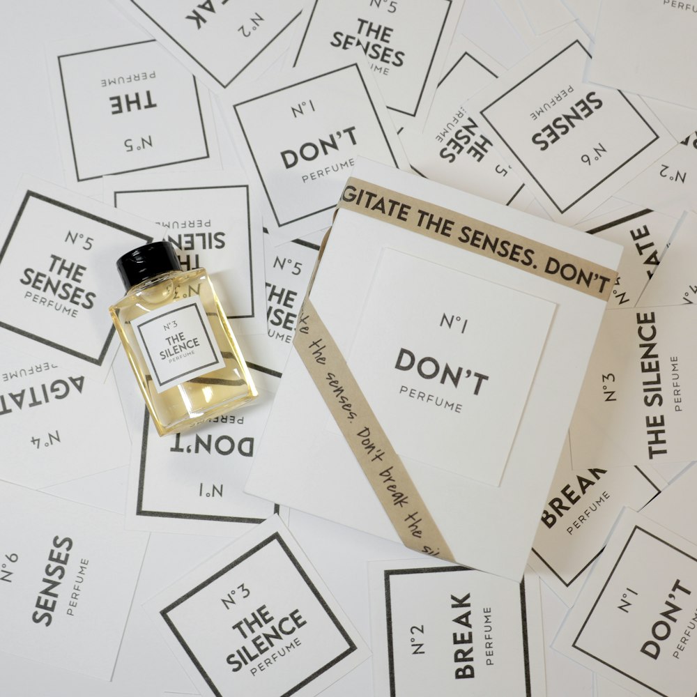 a bottle of perfume sitting on top of a pile of cards