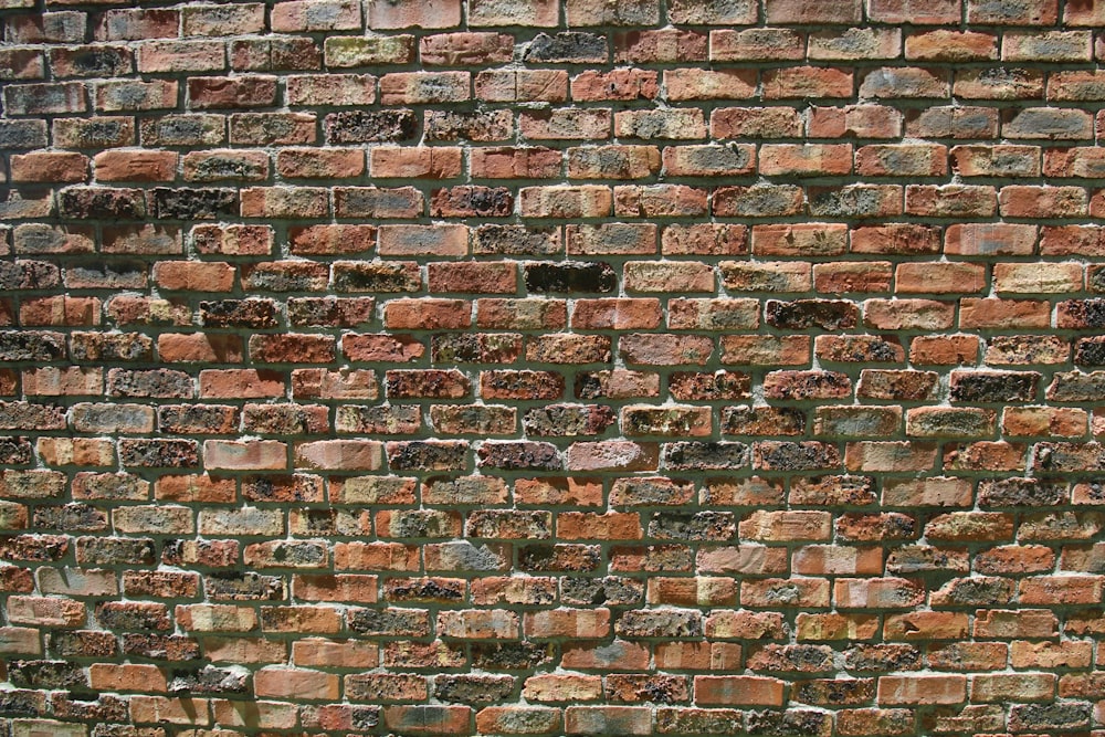 a red fire hydrant sitting in front of a brick wall