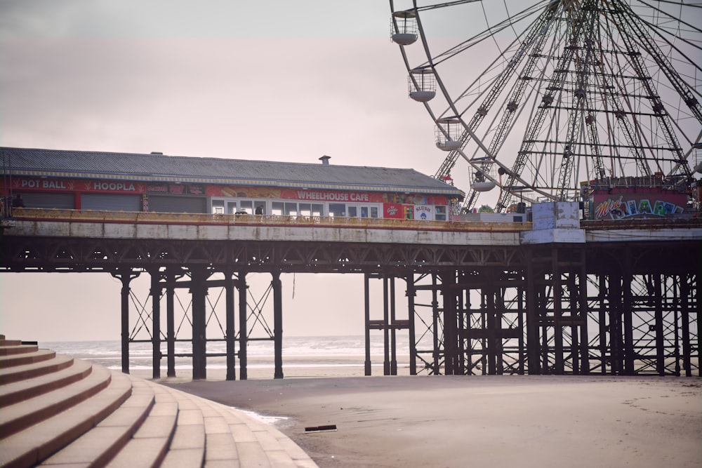 a ferris wheel sitting on top of a pier next to the ocean