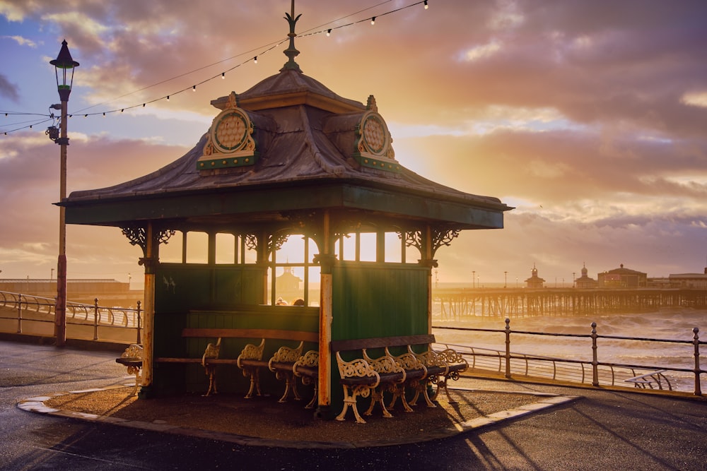 a gazebo sitting on the side of a road next to the ocean