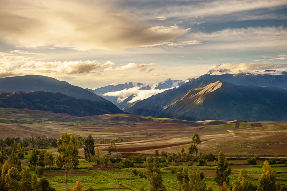 a scenic view of a valley with mountains in the background