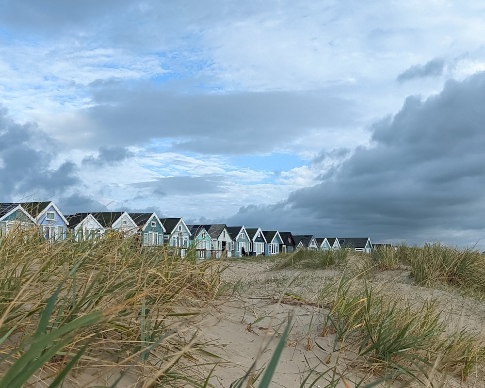 a row of beach huts sitting on top of a sandy beach