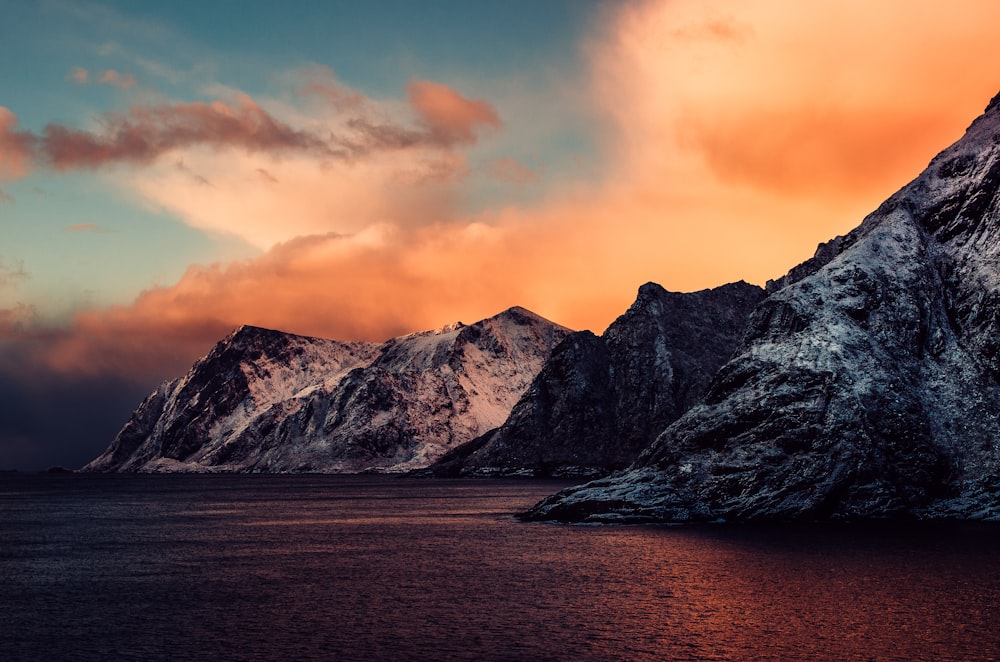 a snow covered mountain with a sunset in the background