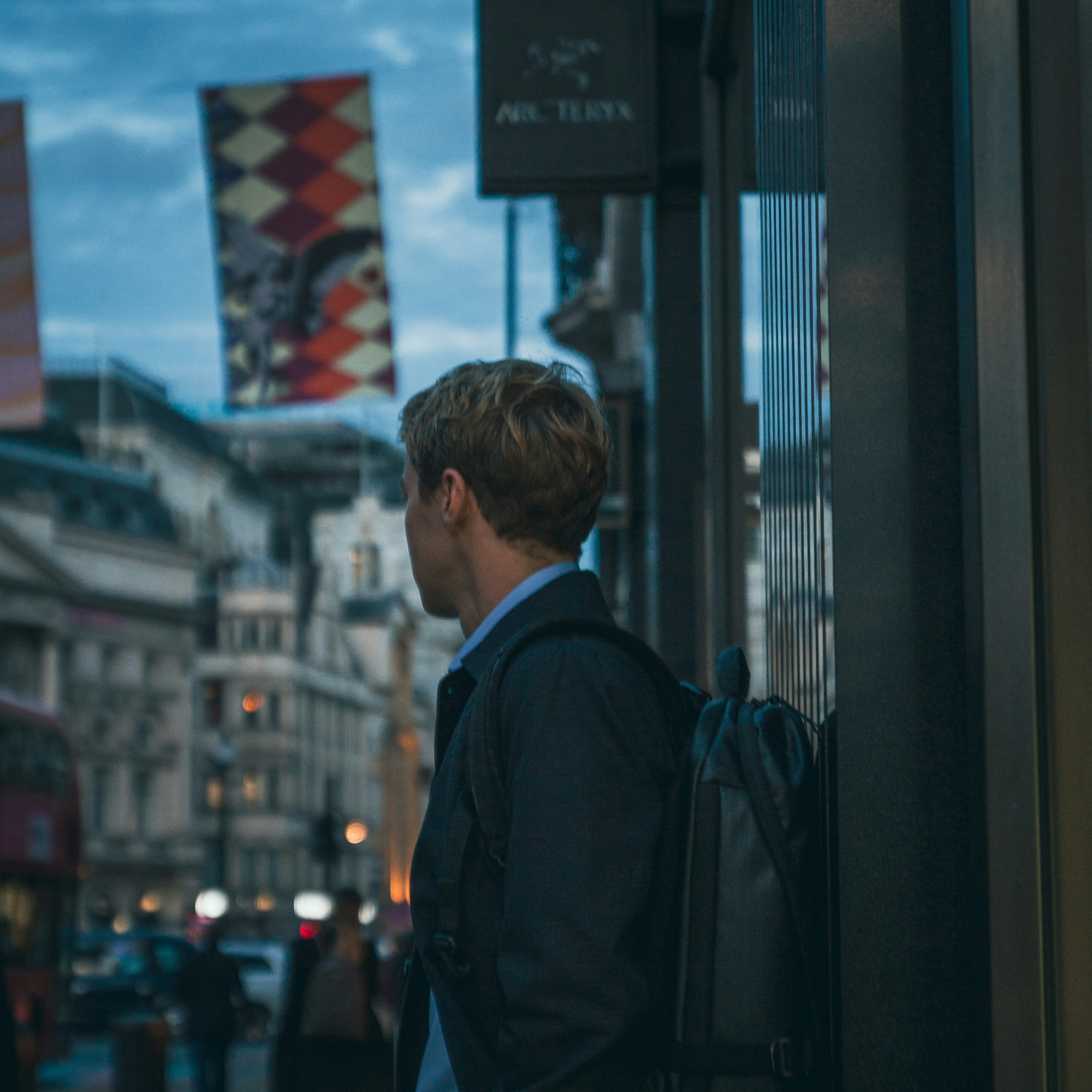 Un homme avec un sac à dos debout dans une rue de la ville