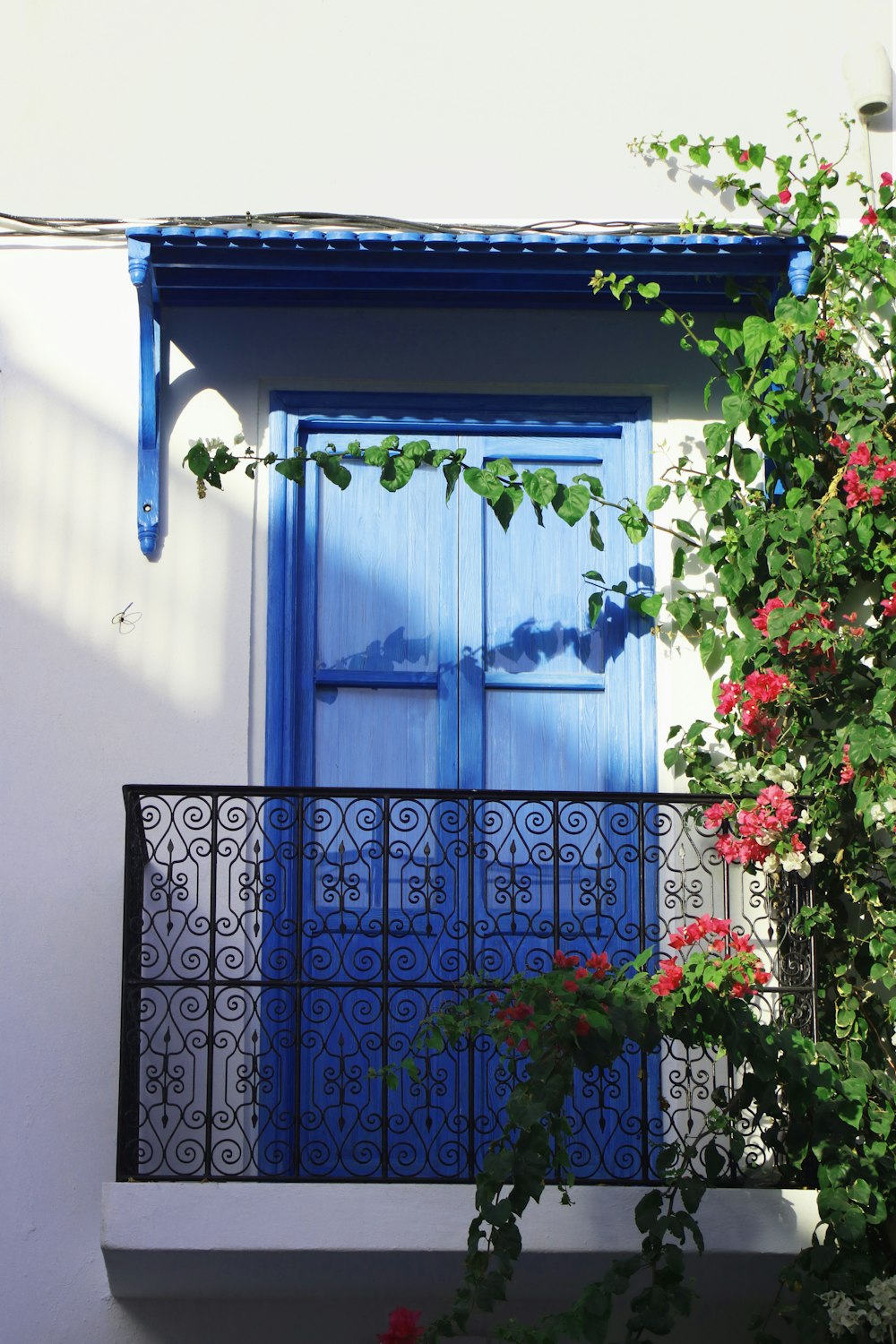 a balcony with a blue door and window