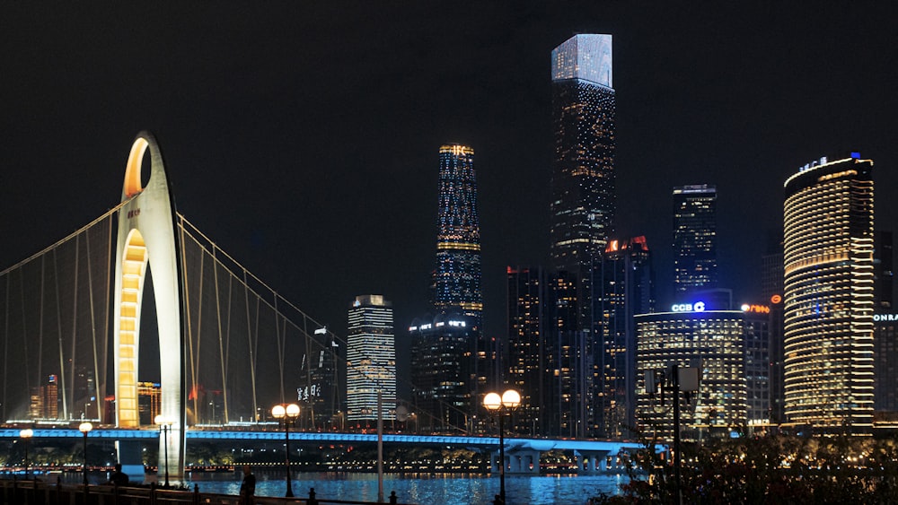 Eine Nachtansicht einer Stadt mit einer Brücke im Vordergrund