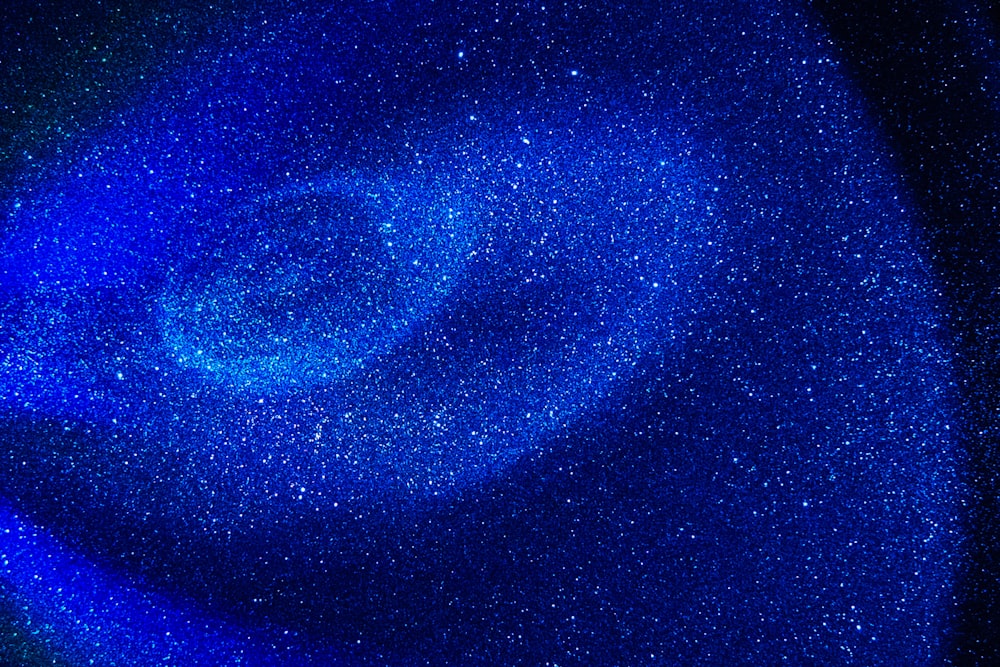 a close up of a blue object with stars in the background