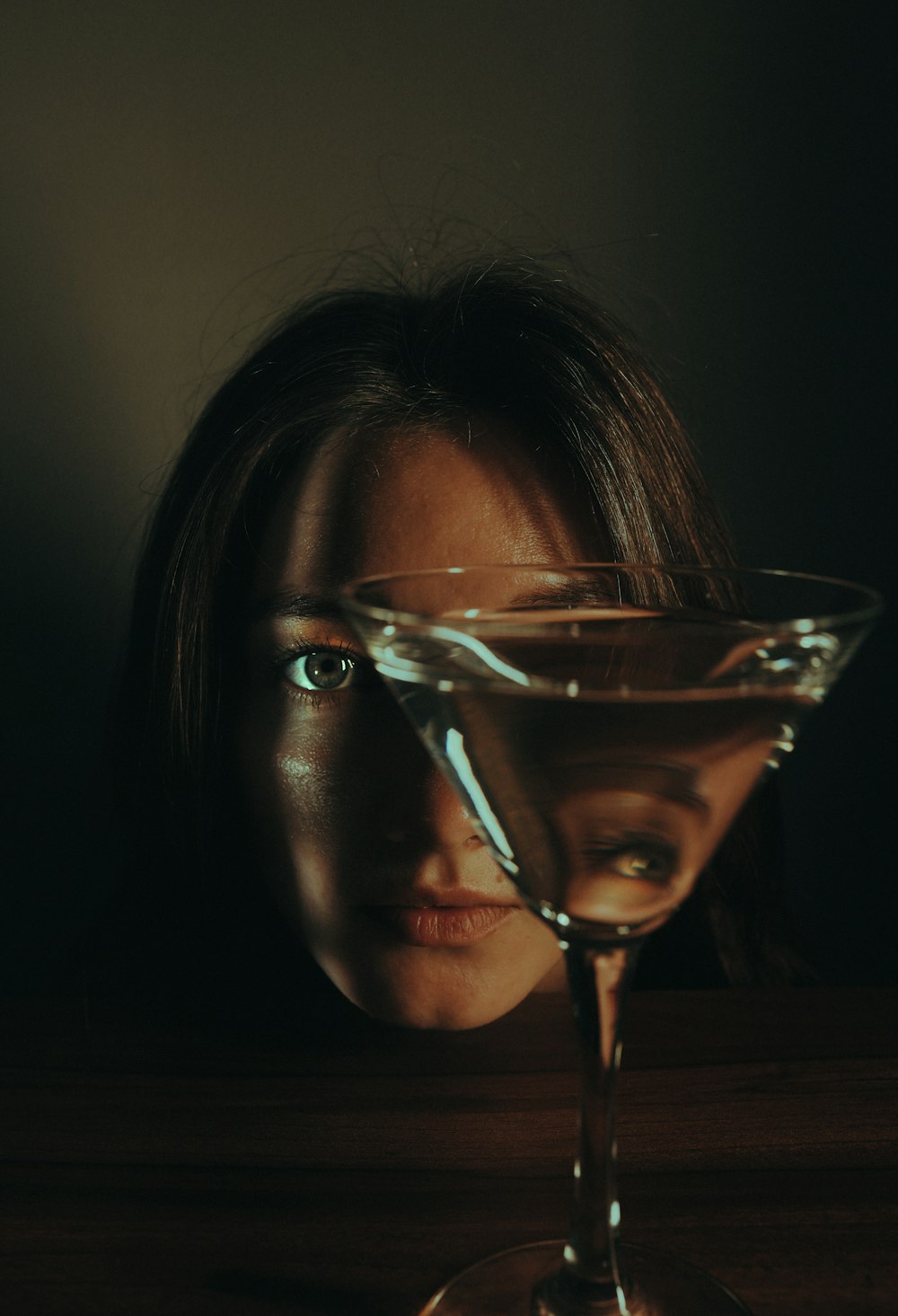 a woman's face behind a martini glass