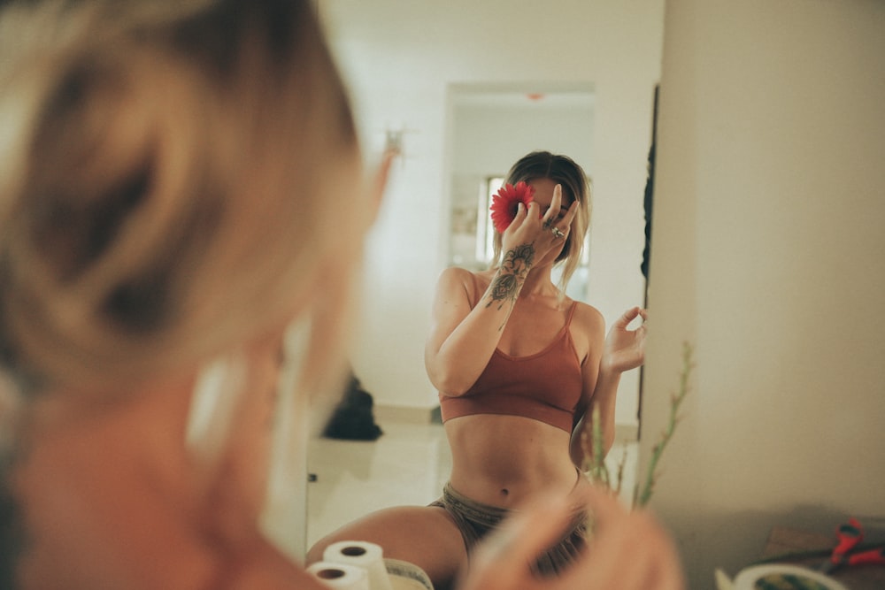 a woman sitting on a bed in front of a mirror