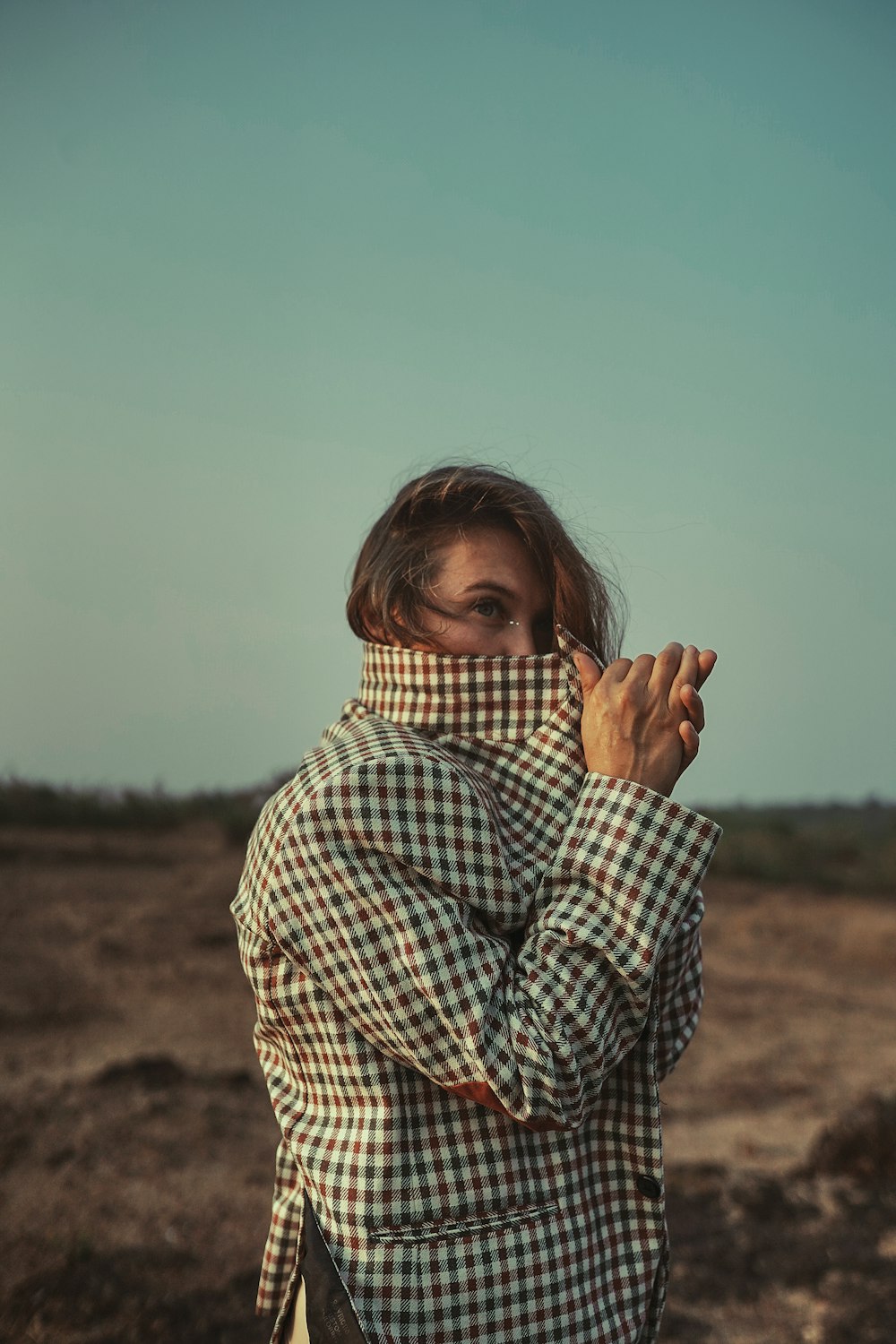 a woman standing in a field with her hands in the air