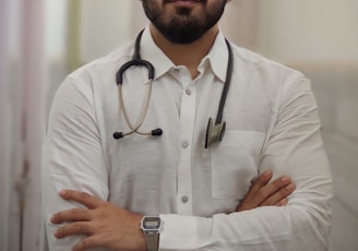 a man with a stethoscope standing with his arms crossed