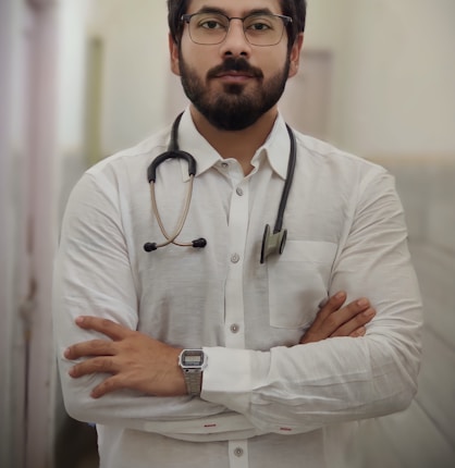 a man with a stethoscope standing with his arms crossed