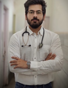 a man with a stethoscope standing with his arms crossed