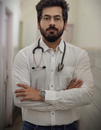a man with a stethoscope standing with his arms crossed