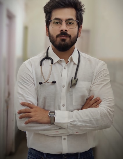 a man with a stethoscope standing with his arms crossed