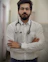 a man with a stethoscope standing with his arms crossed