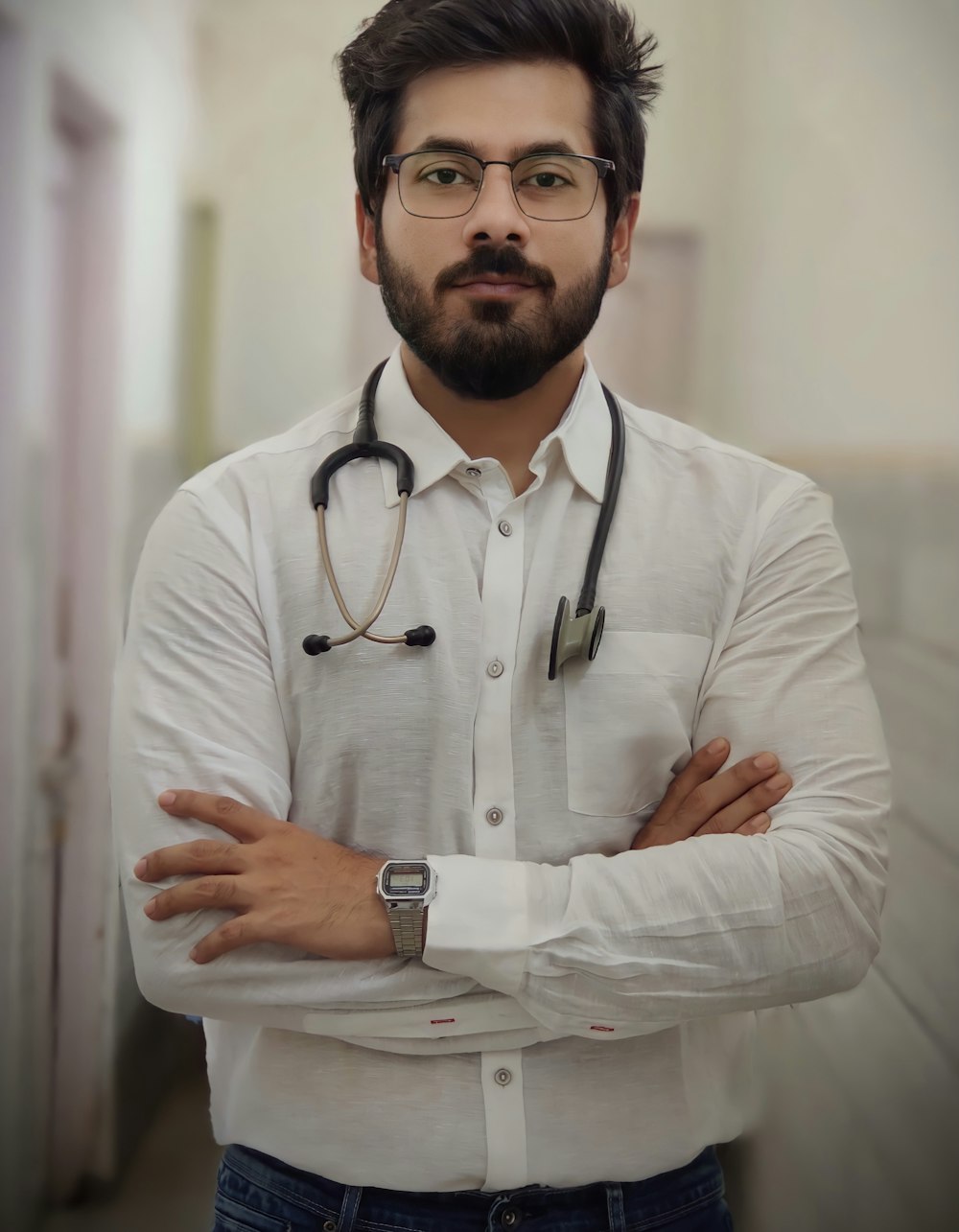 a man with a stethoscope standing with his arms crossed