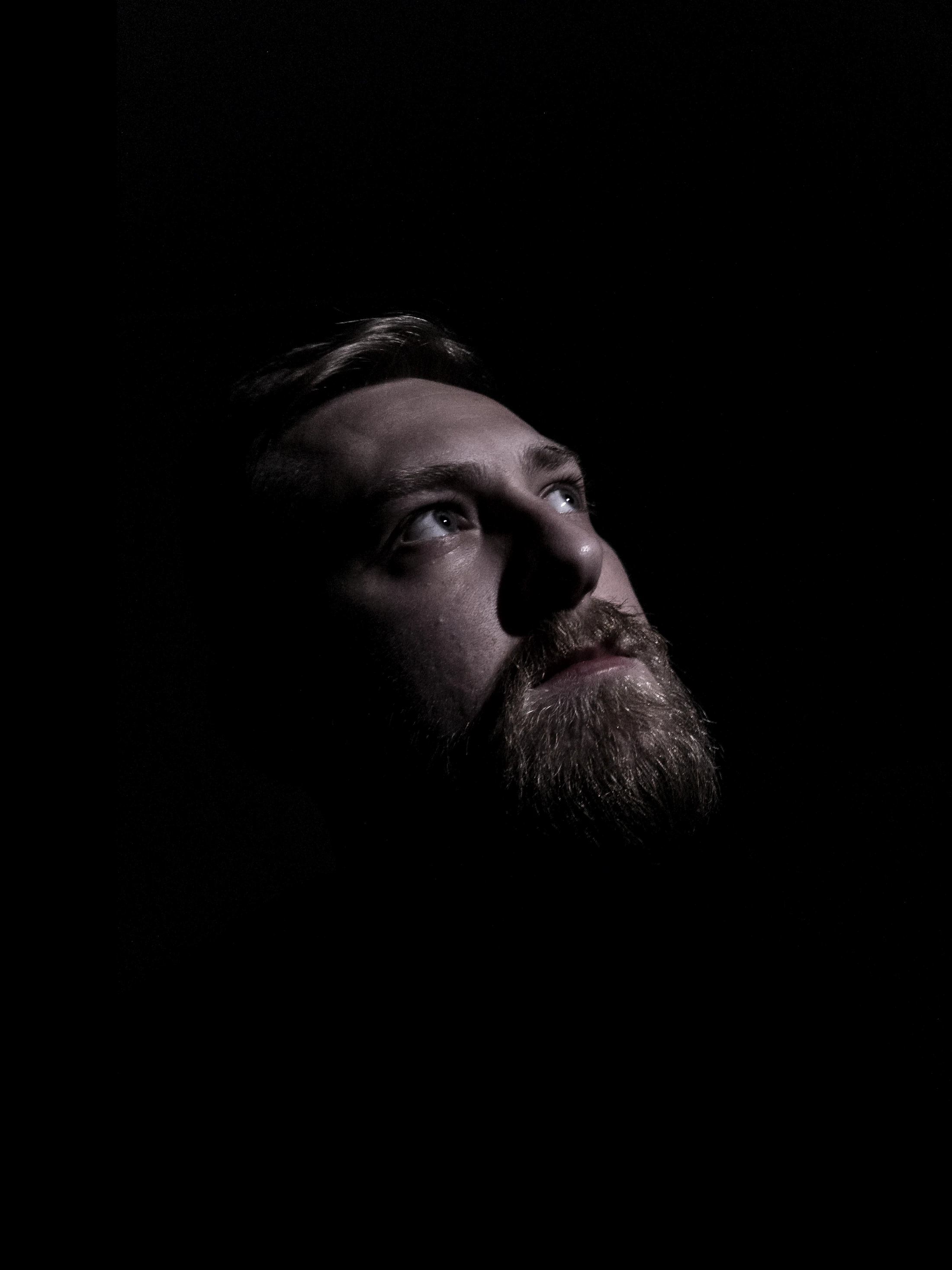 Man in low directional light with composed, healthy skin