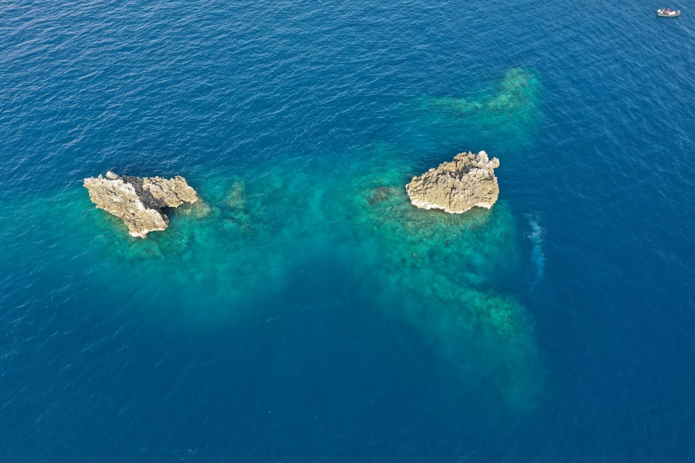 two large rocks in the middle of a body of water