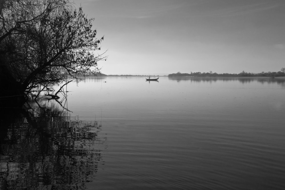 a lone boat floating on top of a large body of water