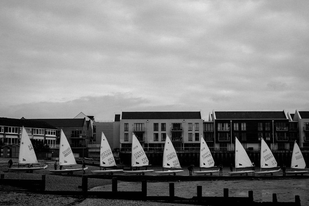 a row of sailboats sitting on top of a body of water