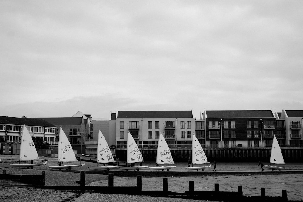 a black and white photo of sailboats on the water