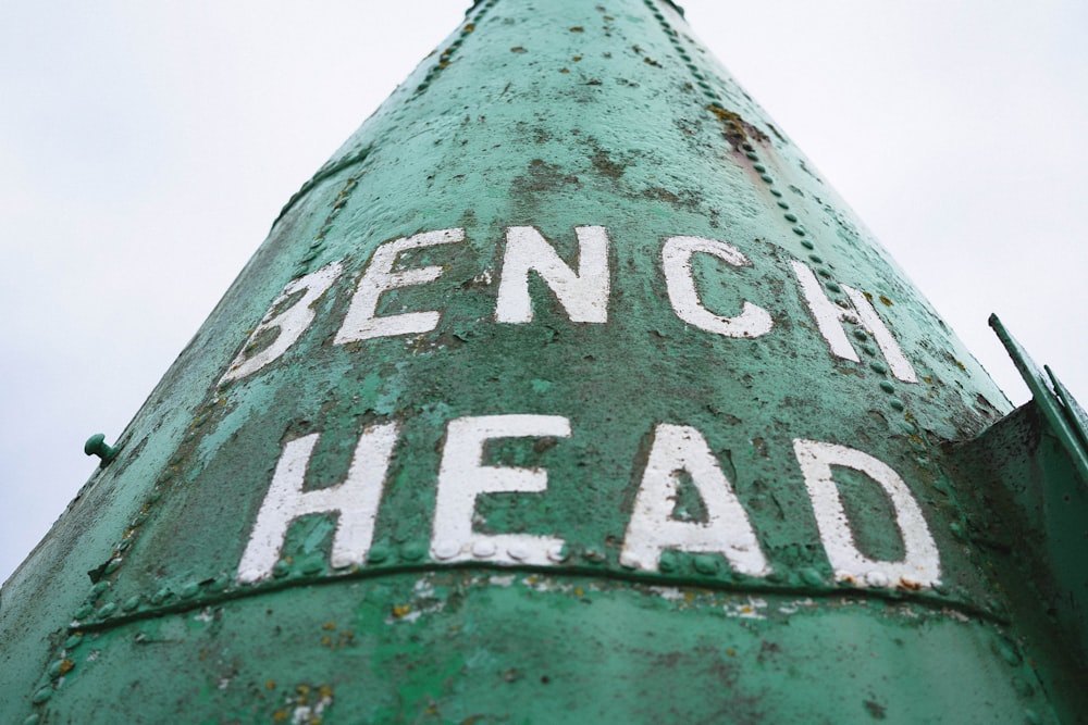 a green pole with white writing on it