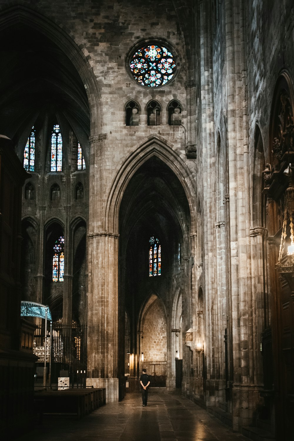 a person standing in a large cathedral with stained glass windows