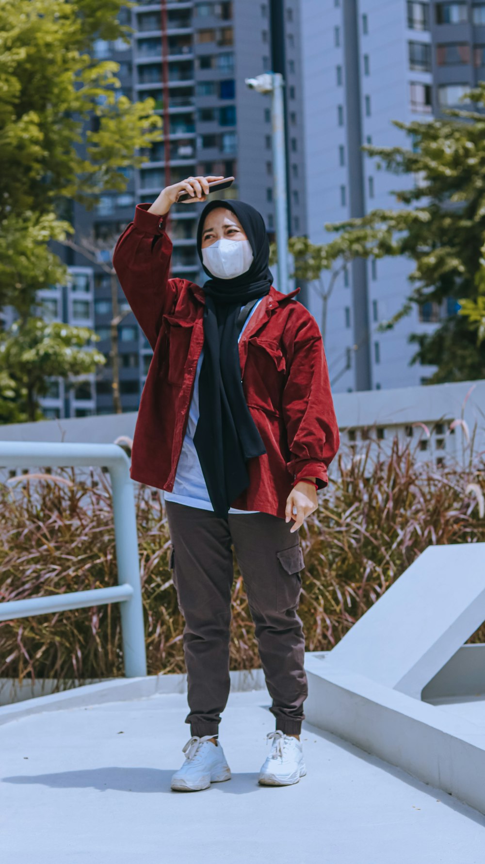 a person wearing a mask standing on a sidewalk