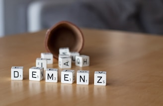 a wooden table topped with dices and letters
