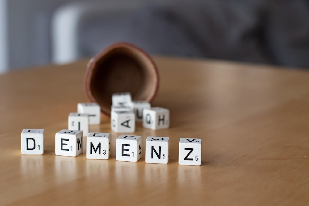 a wooden table topped with dices and letters