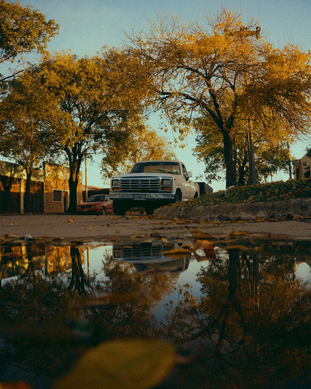 a truck parked next to a puddle of water