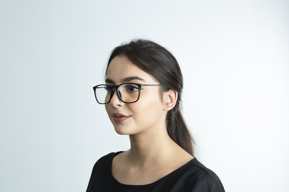 a woman wearing glasses and a black shirt