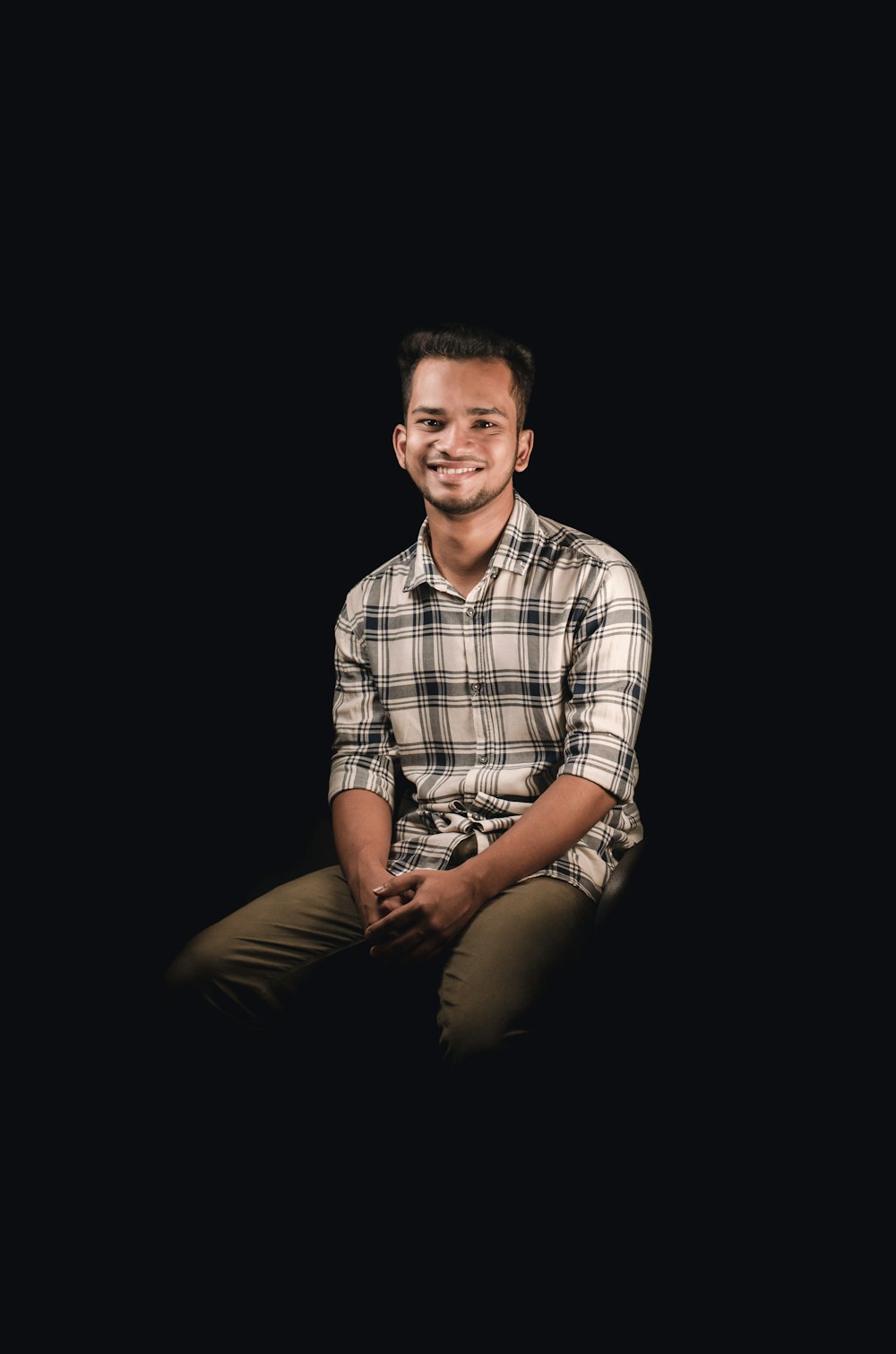 a man sitting in the dark with a smile on his face