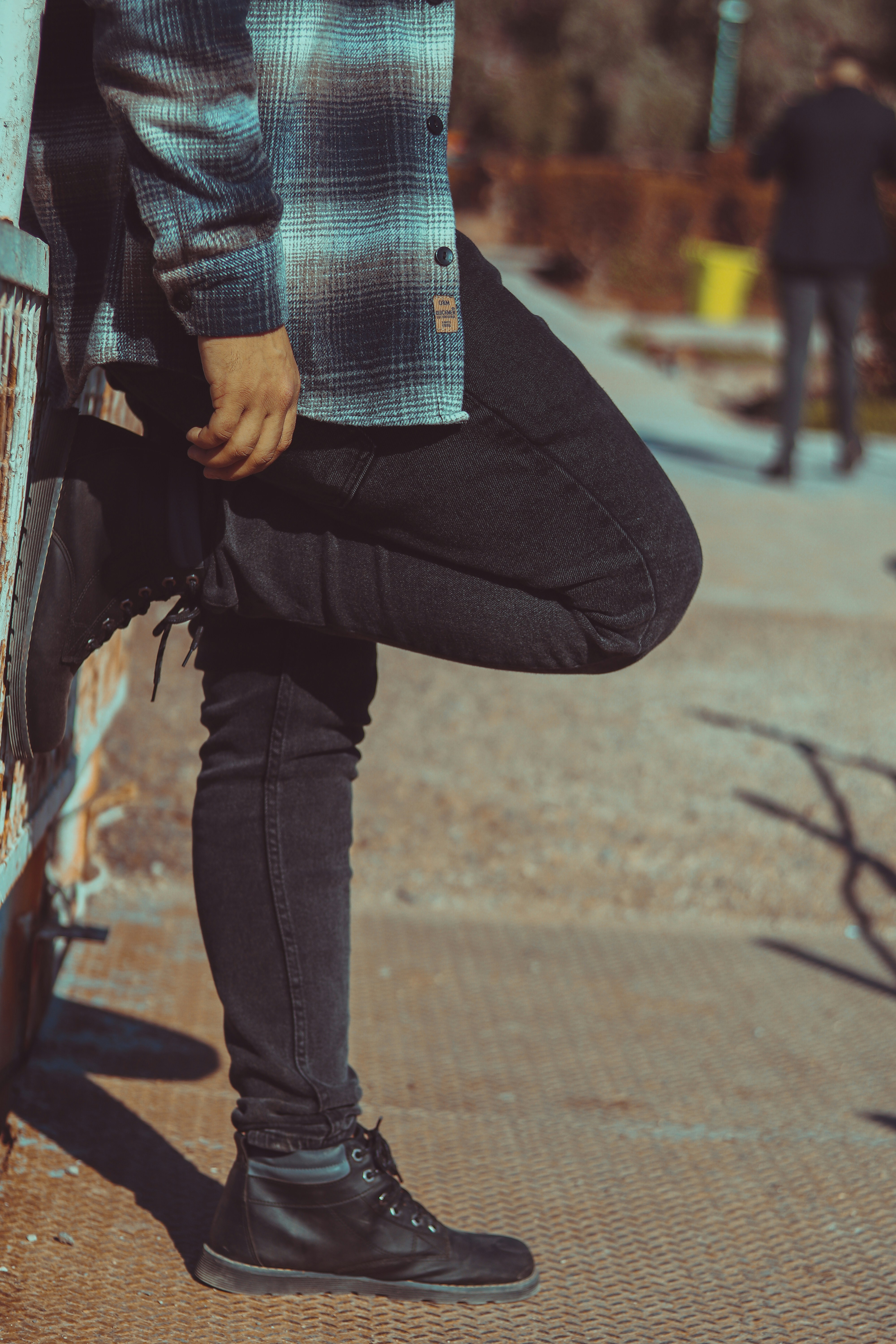 足を地面につけて壁にもたれかかる男